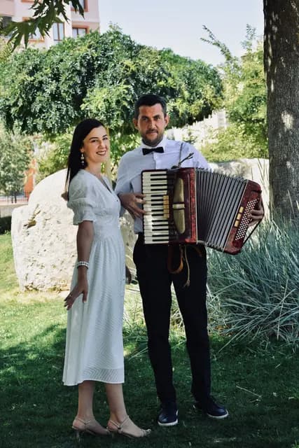 Mlada se smije uz harmonikaša