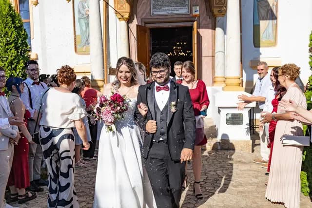 Mladenci izlaze između svatova